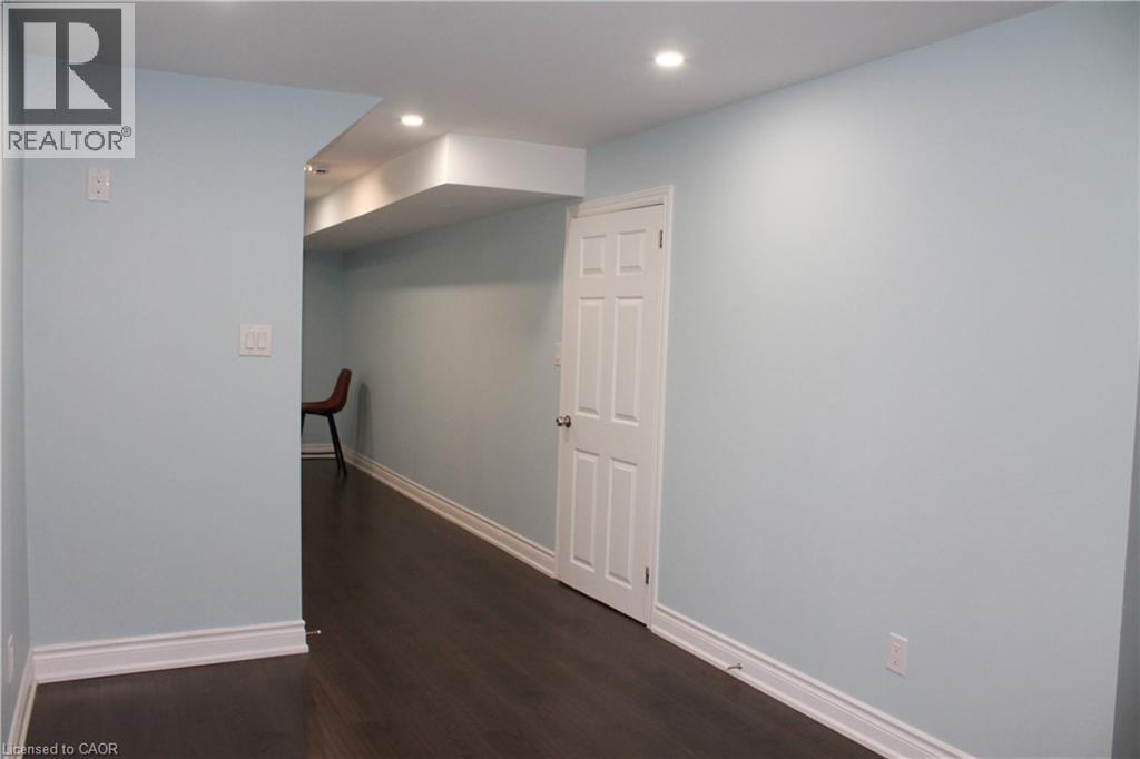 Interior space featuring light blue walls and dark wood-finish flooring - 27 Stillwater Street, Kitchener, ON