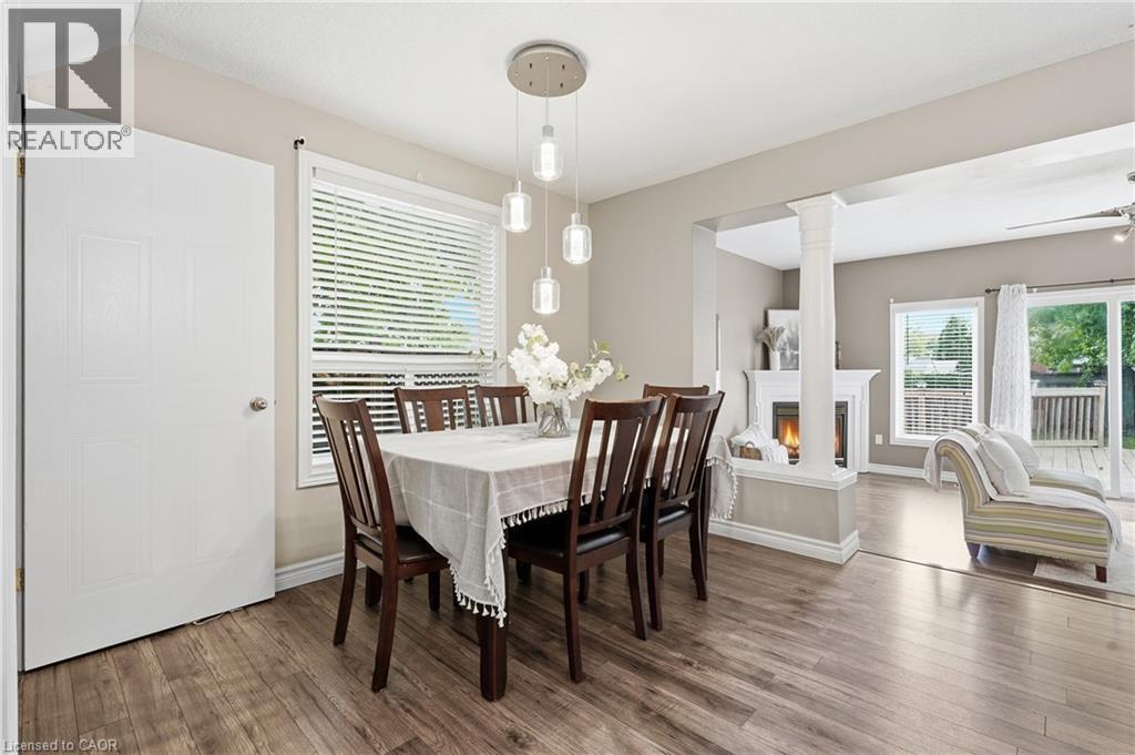 Dining area featuring wood-finish flooring, a window with blinds, and a multi-pendant light fixture - 128 Houghton Street, Cambridge, ON