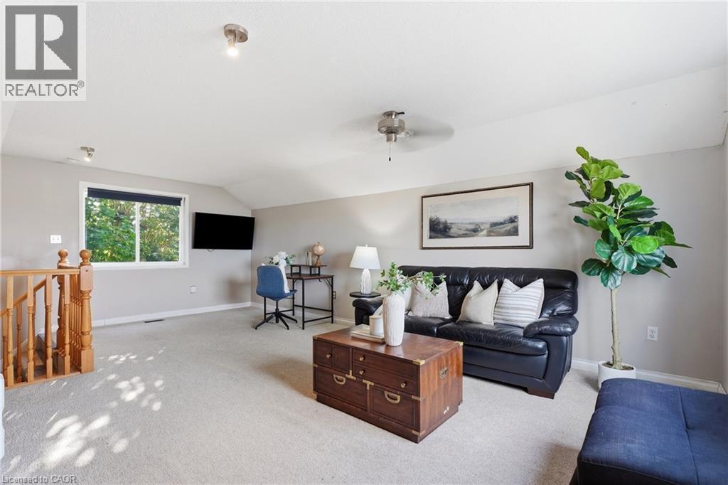 Expansive bonus room featuring sloped ceilings, recessed lighting, neutral carpeting, a window, and a ceiling fan - 128 Houghton Street, Cambridge, ON