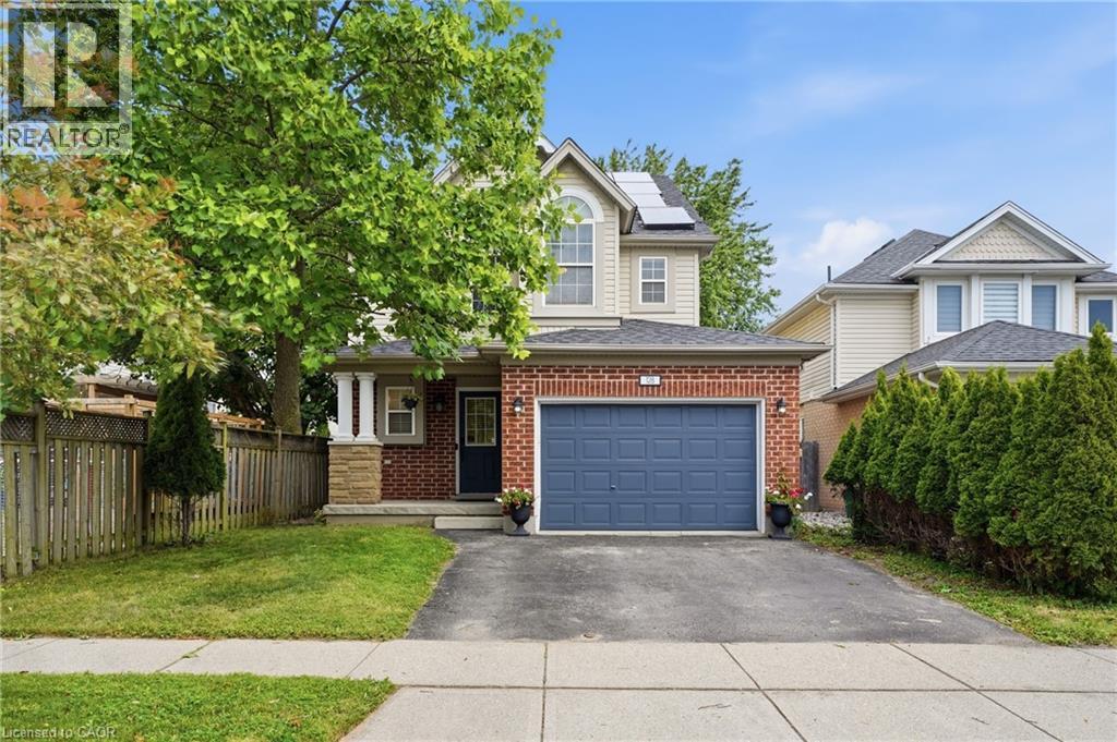 Two-story residence featuring brick and siding exterior, an integrated garage with a blue door, a partial stone facade, and a covered front entry with columns - 128 Houghton Street, Cambridge, ON - Outdoor