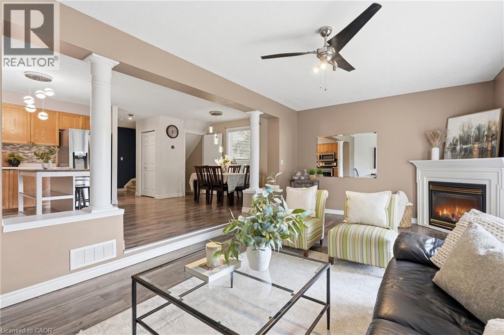 Living room featuring a fireplace with a white mantel, ceiling fan, and wood-finish flooring - 128 Houghton Street, Cambridge, ON - Indoor Photo Showing Living Room With Fireplace
