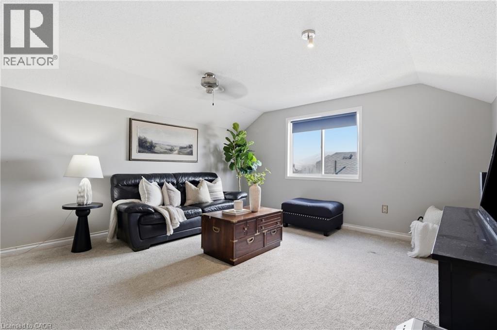 Carpeted room featuring sloped ceilings, a window with exterior views, and neutral wall paint - 128 Houghton Street, Cambridge, ON - Indoor