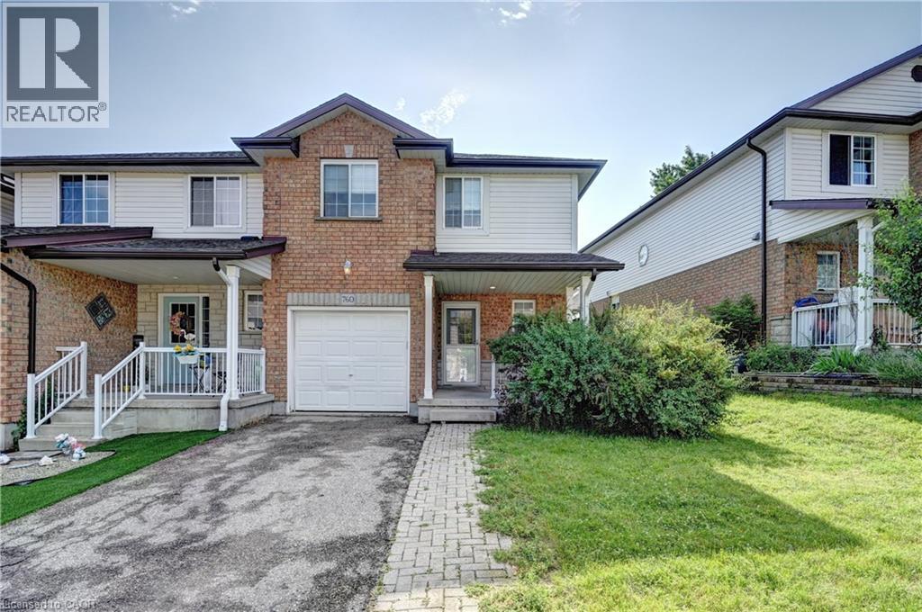 Brick and siding exterior featuring a covered front porch, an attached garage, a paved driveway, and a stone paver walkway - 760 Paris Boulevard, Waterloo, ON
