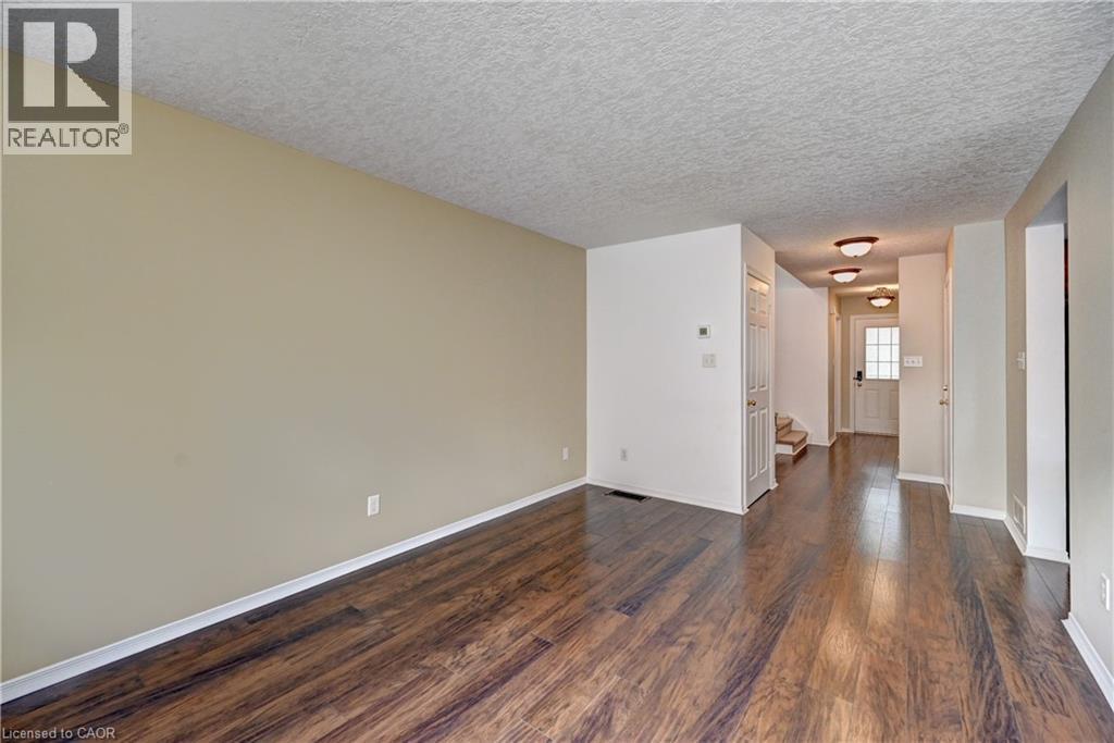 Open concept living area featuring wood-finish flooring, neutral wall paint, and white trim - 760 Paris Boulevard, Waterloo, ON