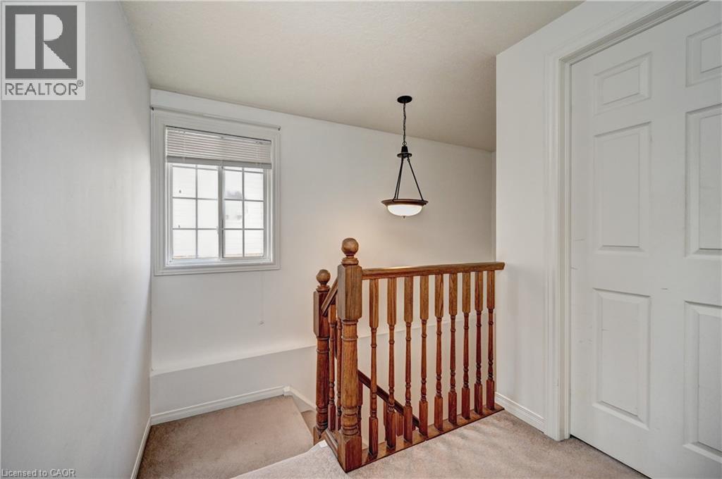 Upper level landing featuring light beige carpet, white painted walls, and a multi-pane window with blinds - 760 Paris Boulevard, Waterloo, ON