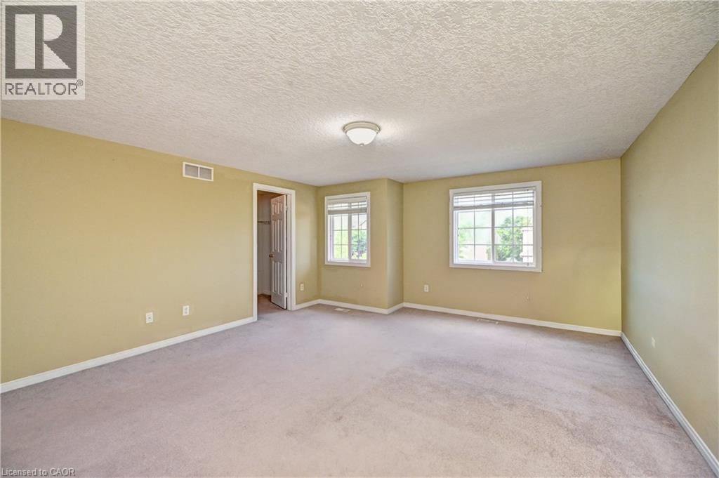 Spacious room with light tan walls and light-colored carpeting - 760 Paris Boulevard, Waterloo, ON