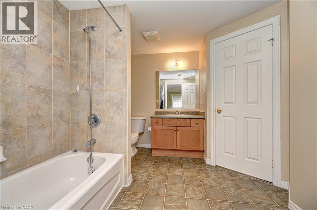 Bathroom featuring a white bathtub, ceramic tile surround, and a chrome shower fixture - 760 Paris Boulevard, Waterloo, ON