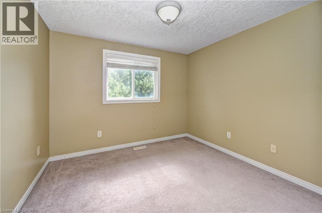 Room featuring light tan walls, a white framed window, and neutral carpet flooring - 760 Paris Boulevard, Waterloo, ON