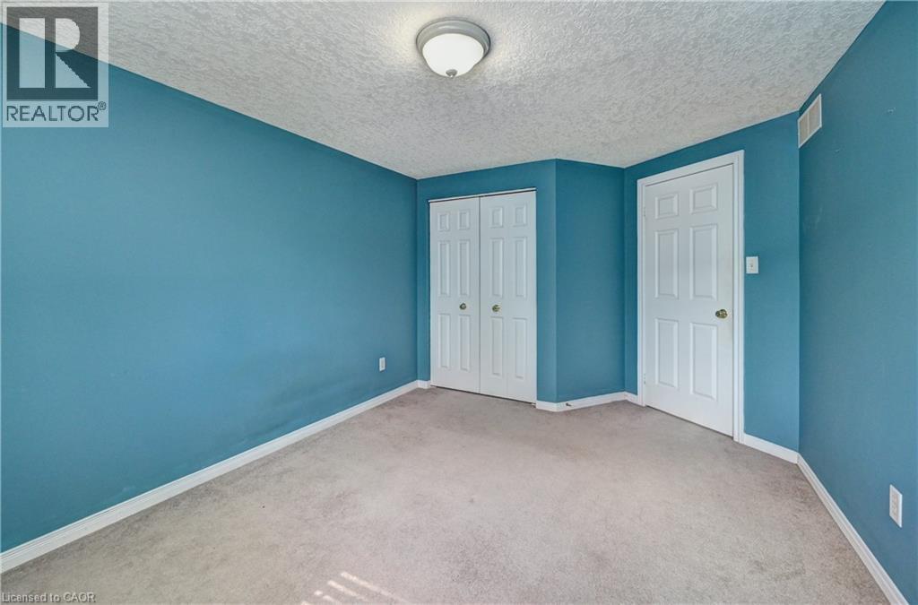 Room featuring blue painted walls, neutral carpet flooring, and white baseboards - 760 Paris Boulevard, Waterloo, ON