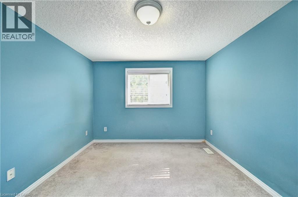 Interior room featuring blue wall paint, light-colored carpeting, and a white ceiling with a textured finish - 760 Paris Boulevard, Waterloo, ON