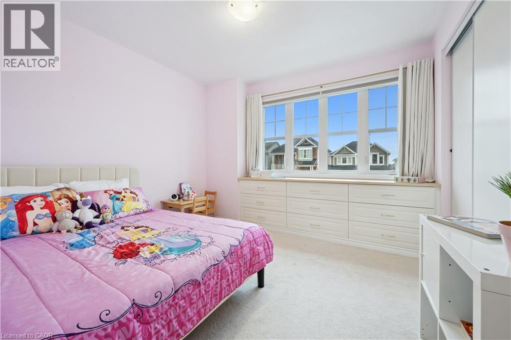 Bedroom featuring a large window with multiple panes, built-in lower cabinetry, light-toned walls, and a light carpet - 87 Ridge Road, Cambridge, ON