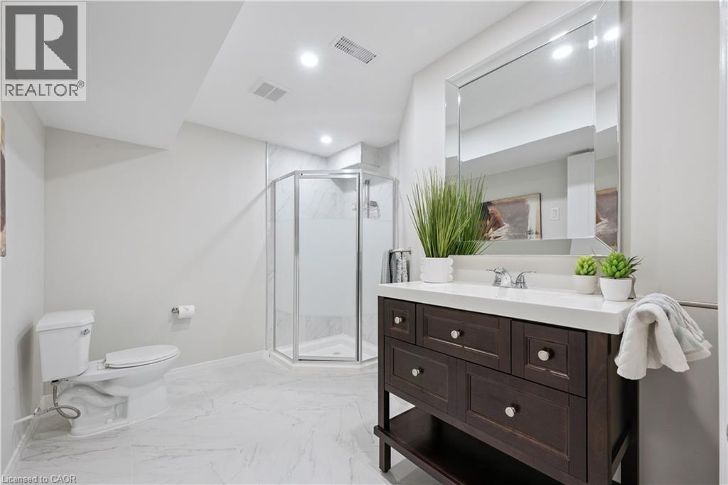 Bathroom featuring a dark wood-finish vanity with a white countertop and chrome fixtures - 87 Ridge Road, Cambridge, ON