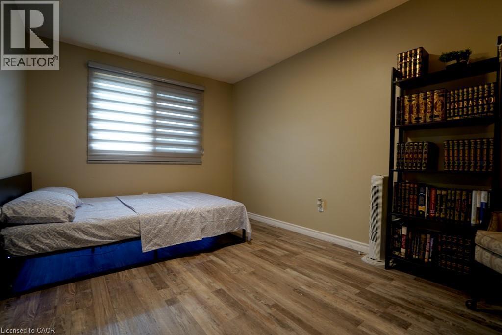 Room featuring wood-finish flooring, a window with horizontal blinds, and baseboard trim - 147 Muriel Crescent, London, ON