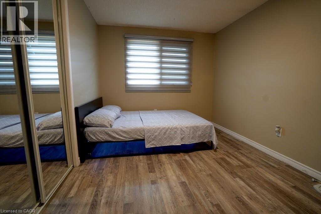 Room featuring wood-finish flooring, neutral wall paint, and a window with horizontal blinds - 147 Muriel Crescent, London, ON