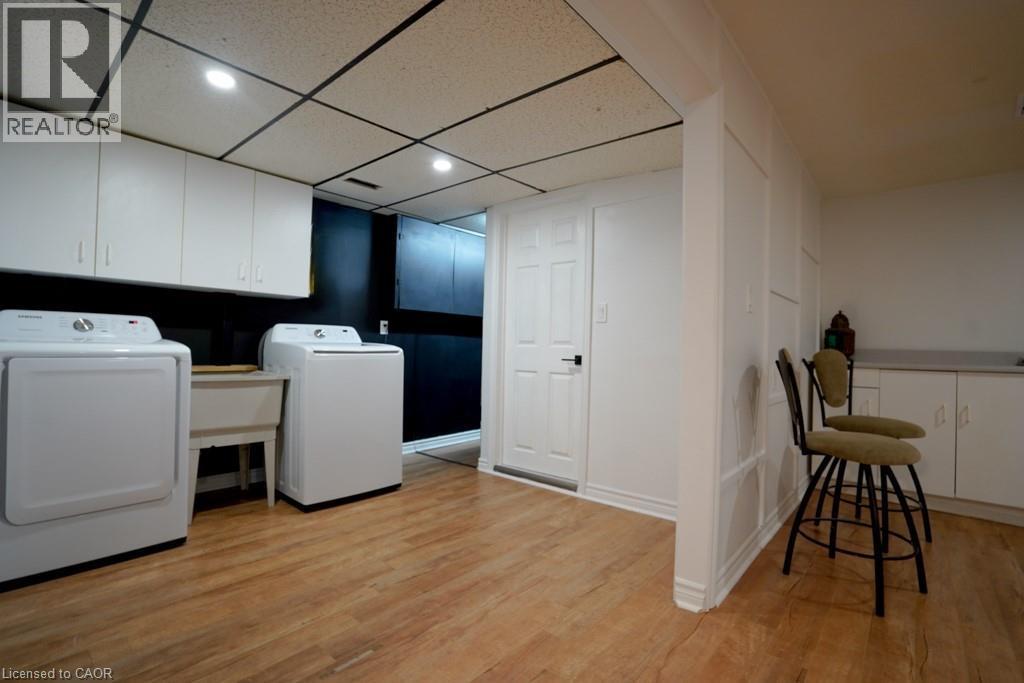 Dedicated laundry area featuring a utility sink and a washer and dryer set - 147 Muriel Crescent, London, ON
