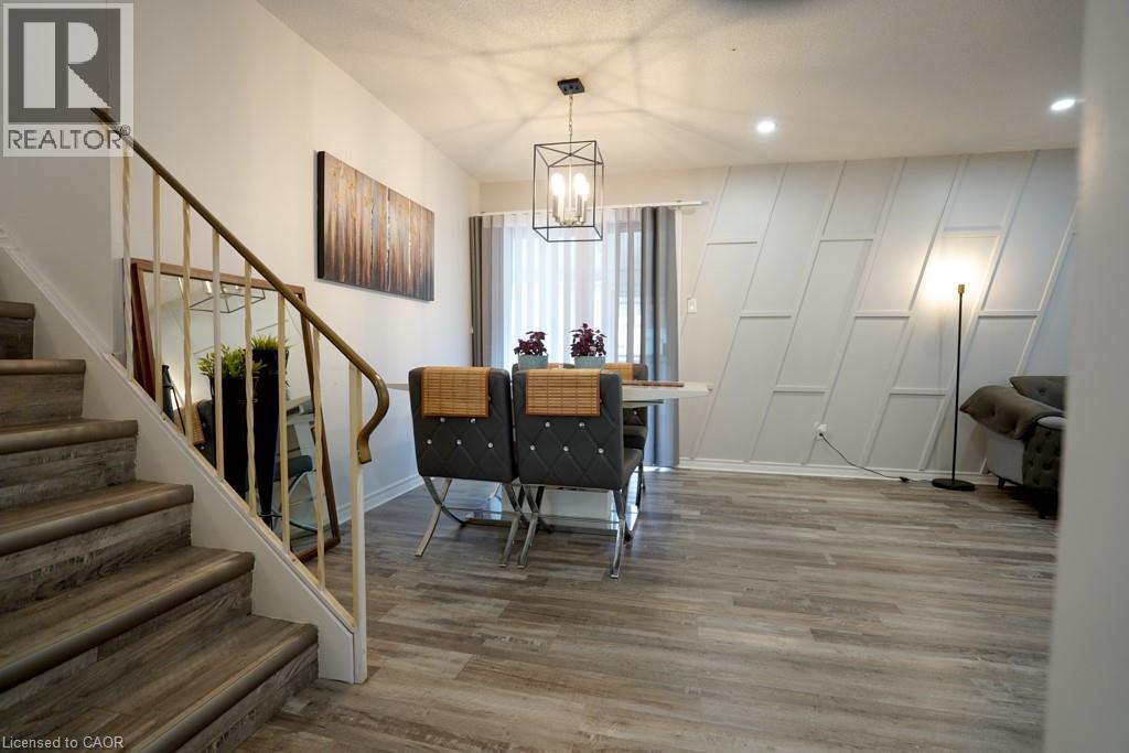 Wood-finish staircase with white risers and a metal handrail - 147 Muriel Crescent, London, ON