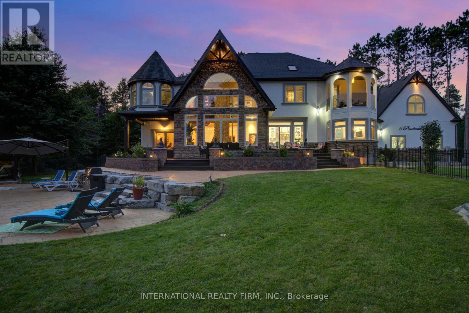 Stunning architectural lighting at twilight. - 6 Pinehurst Lane, Springwater, ON - Outdoor With Facade