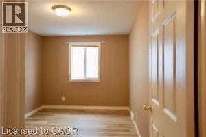 Room featuring wood-finish flooring, neutral wall paint, and a window with natural light - 17 Hawkswood Drive, Kitchener, ON
