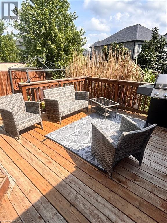 Spacious outdoor wood deck with perimeter wood railing, offering ample area for seating and outdoor cooking appliances - 17 Hawkswood Drive, Kitchener, ON