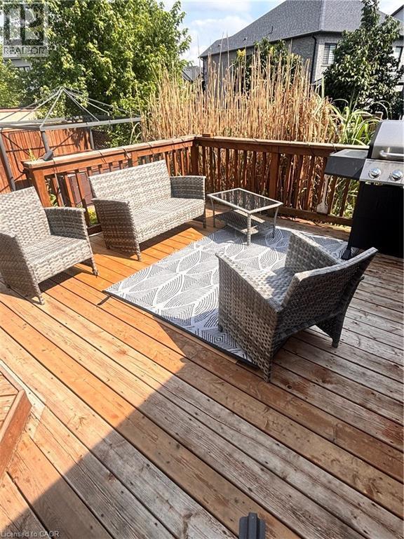 Spacious wood deck featuring a protective railing and tall natural screening - 17 Hawkswood Drive, Kitchener, ON