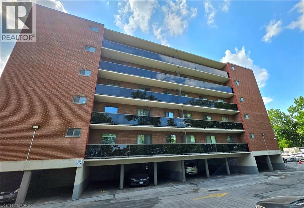 Brick exterior building featuring multiple levels of balconies with dark glass railings - 2373 E King Street E Unit# 37, Hamilton, ON