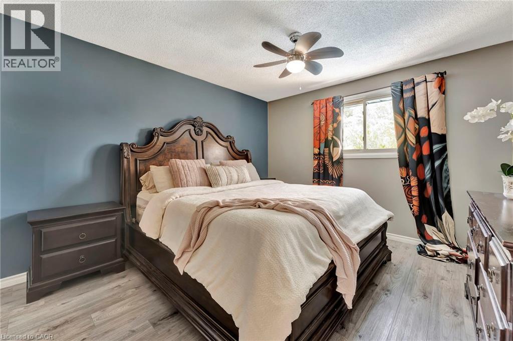 Spacious room featuring wood-finish flooring, a ceiling fan with integrated lighting, and a window for natural light - 192 Myers Road, Cambridge, ON