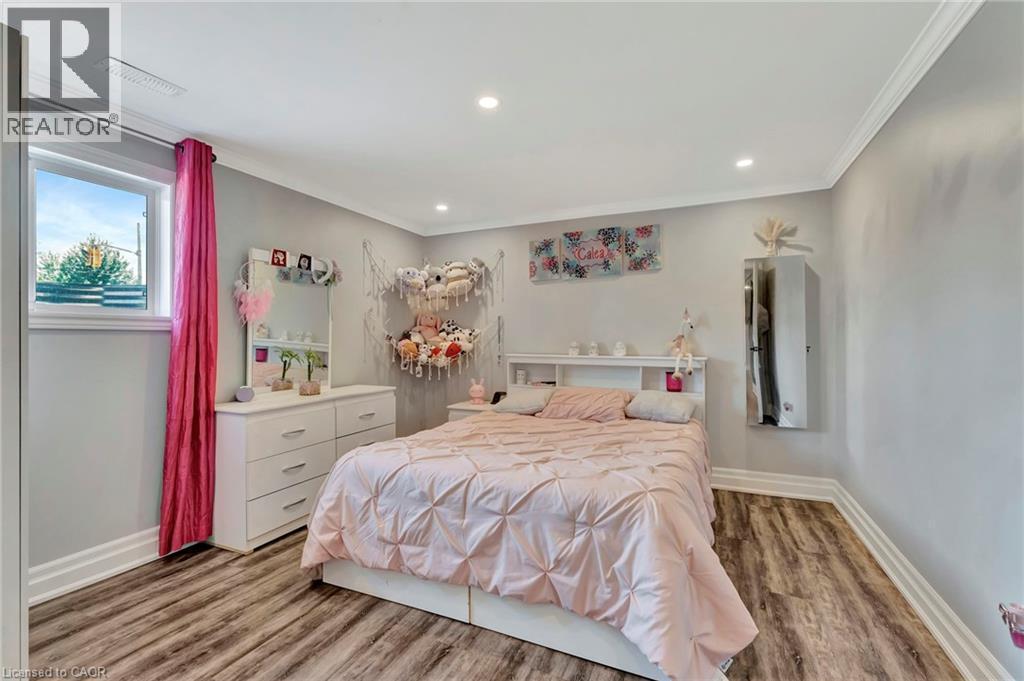 Recessed lighting illuminates this space featuring wood-finish flooring and crown molding - 192 Myers Road, Cambridge, ON