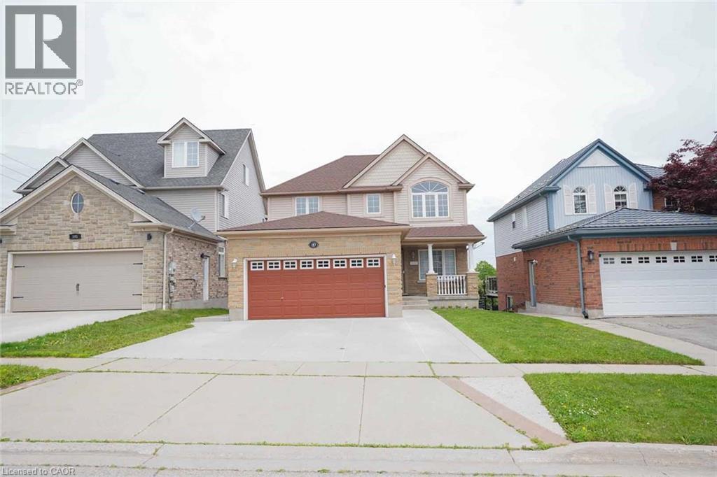Two-story residence featuring a covered front porch, a two-car garage with a red door, and a concrete driveway - 187 Adler Drive, Cambridge, ON - Outdoor With Facade