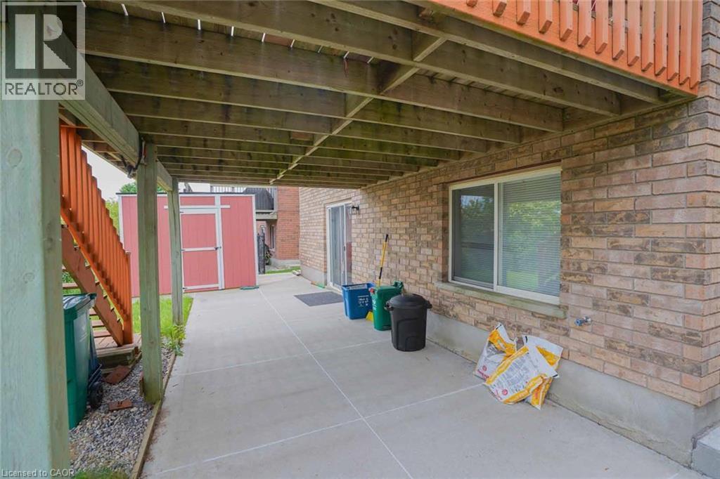 Covered concrete patio with overhead wood joists, featuring a sliding glass door and a large sliding window - 187 Adler Drive, Cambridge, ON - Outdoor With Exterior