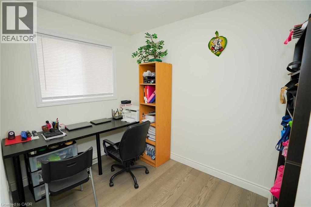 Bright room featuring a window with white blinds, wood-finish flooring, and light-colored walls - 187 Adler Drive, Cambridge, ON - Indoor Photo Showing Other Room