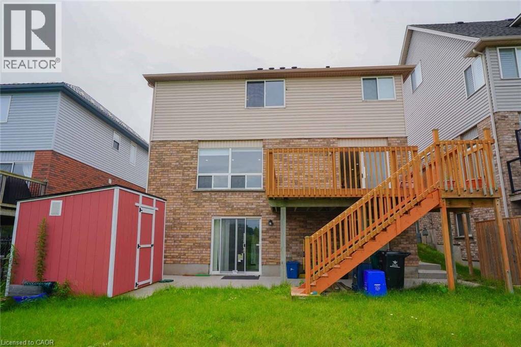 Rear exterior featuring a multi-level wooden deck with staircase, brick lower level, siding upper level, and multiple windows - 187 Adler Drive, Cambridge, ON - Outdoor With Exterior
