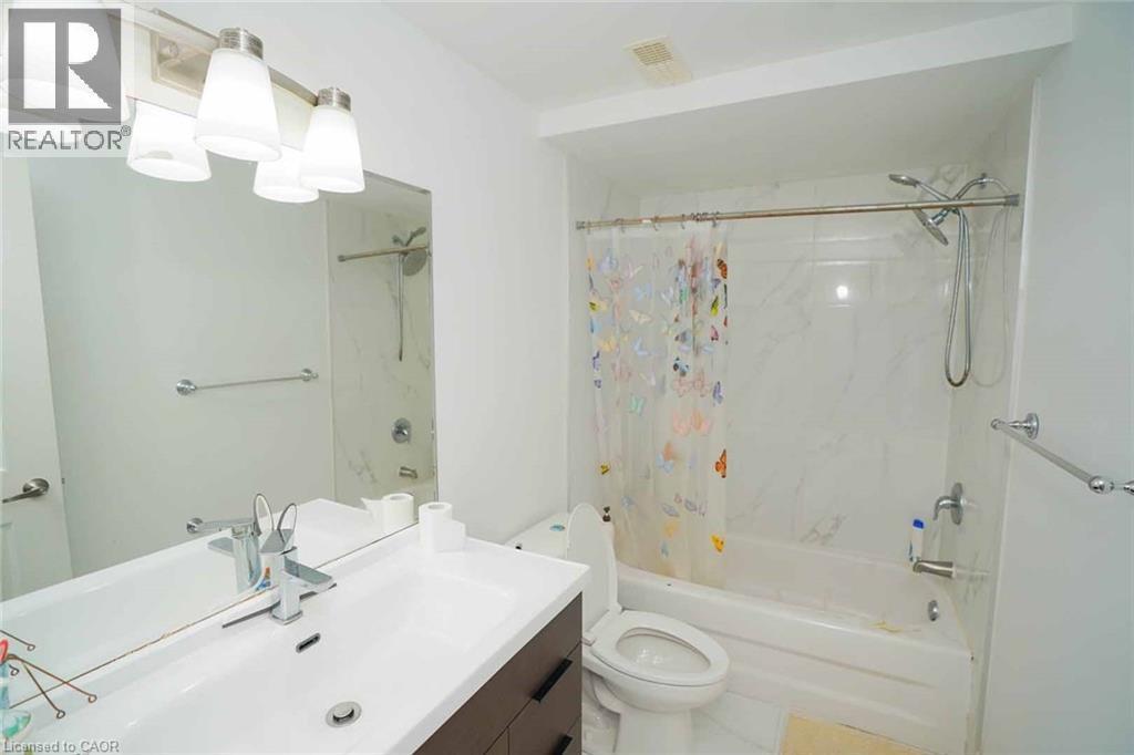 Bathroom featuring a white vanity with integrated sink, chrome faucet, and a wall-mounted mirror - 187 Adler Drive, Cambridge, ON - Indoor Photo Showing Bathroom