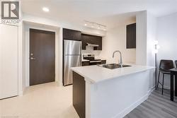 Kitchen featuring a white countertop island with a double stainless steel sink and a gooseneck faucet - 