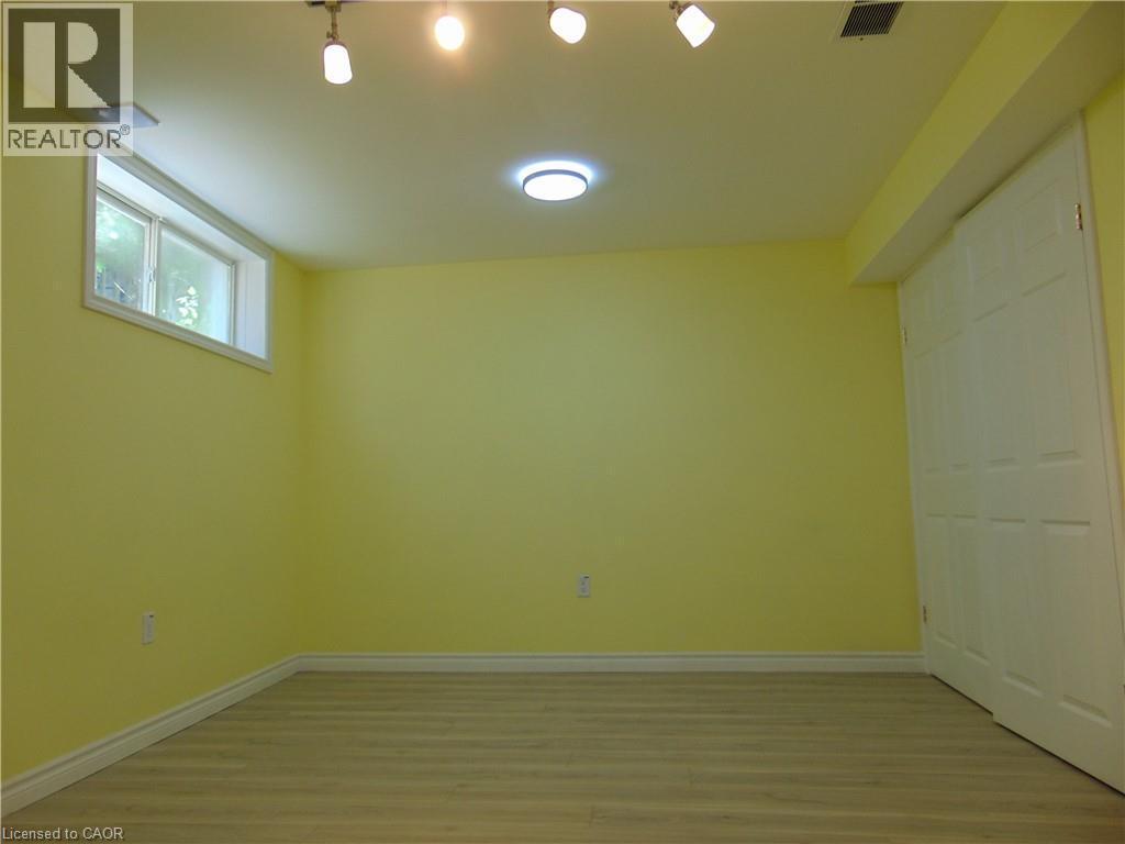 Room featuring light-toned wood-finish flooring, white baseboards, and a neutral wall color - 214 Snowdrop Crescent, Kitchener, ON