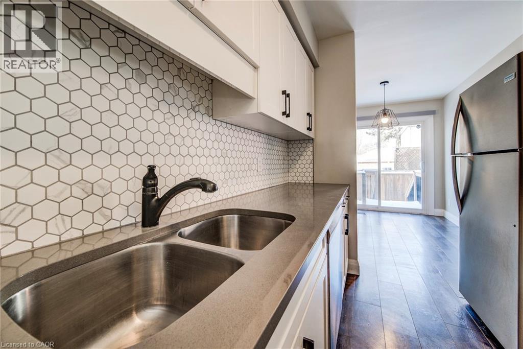 Kitchen area featuring a double basin stainless steel sink with a matte black faucet - 415-435 Garden Street Unit# 421, Cambridge, ON