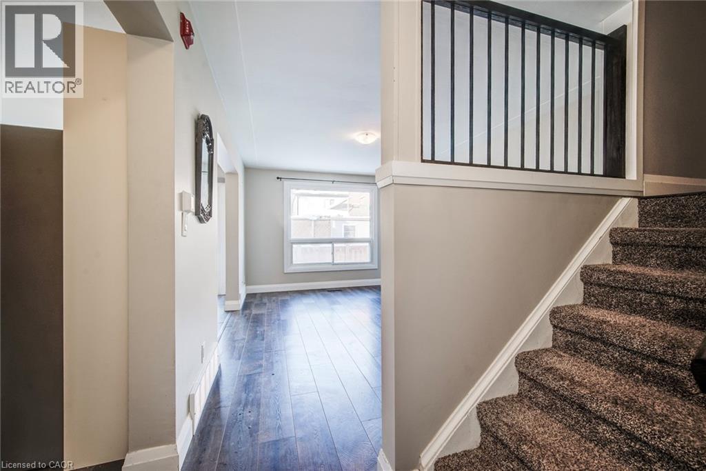 Carpeted staircase with white trim and a black metal balustrade - 415-435 Garden Street Unit# 421, Cambridge, ON