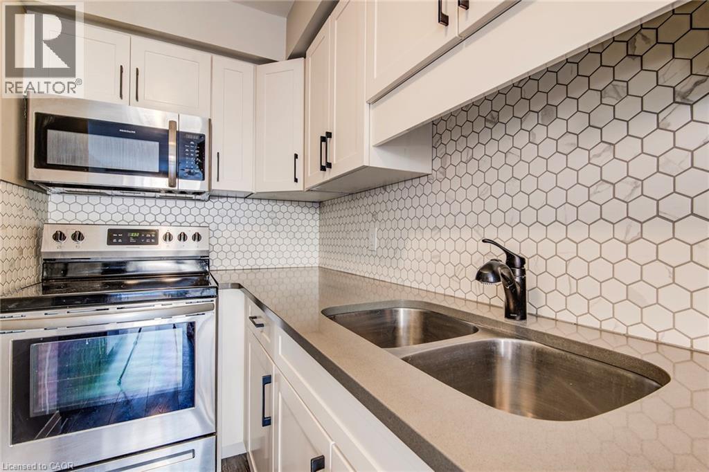 Contemporary kitchen featuring light cabinetry with dark hardware - 415-435 Garden Street Unit# 421, Cambridge, ON