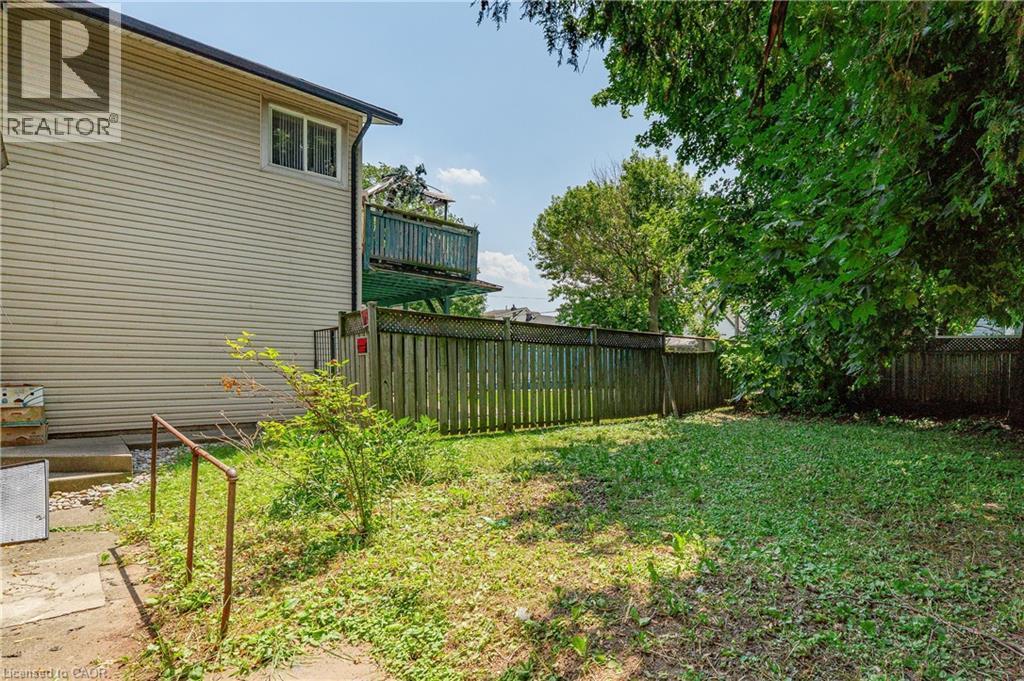 Expansive grassy yard with wood fencing and mature trees - 1274 Barton Street E, Hamilton, ON