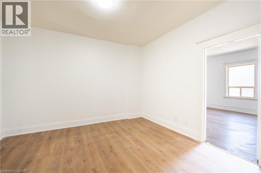 Bright interior space featuring wood-finish flooring, white baseboards, and a neutral wall palette - 1274 Barton Street E, Hamilton, ON