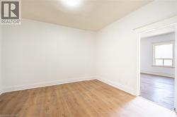 Bright interior space featuring wood-finish flooring, white baseboards, and a neutral wall palette -