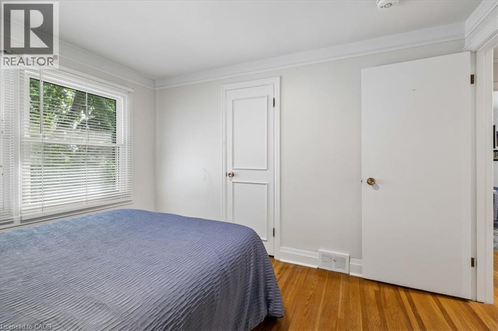 Hardwood flooring featuring a double-hung window with blinds, crown molding, and white trim - 80 Maclennan Avenue, Hamilton, ON - Indoor Photo Showing Bedroom