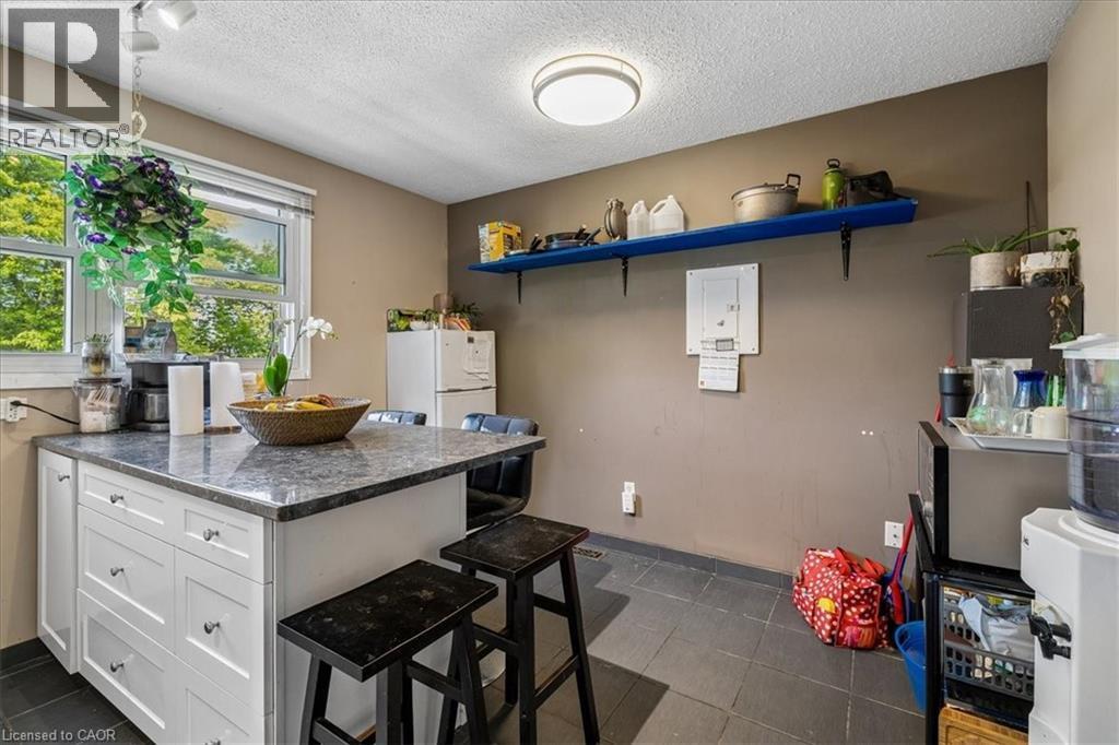 Kitchen island featuring a stone-finish countertop with built-in storage drawers - 80 Maclennan Avenue, Hamilton, ON