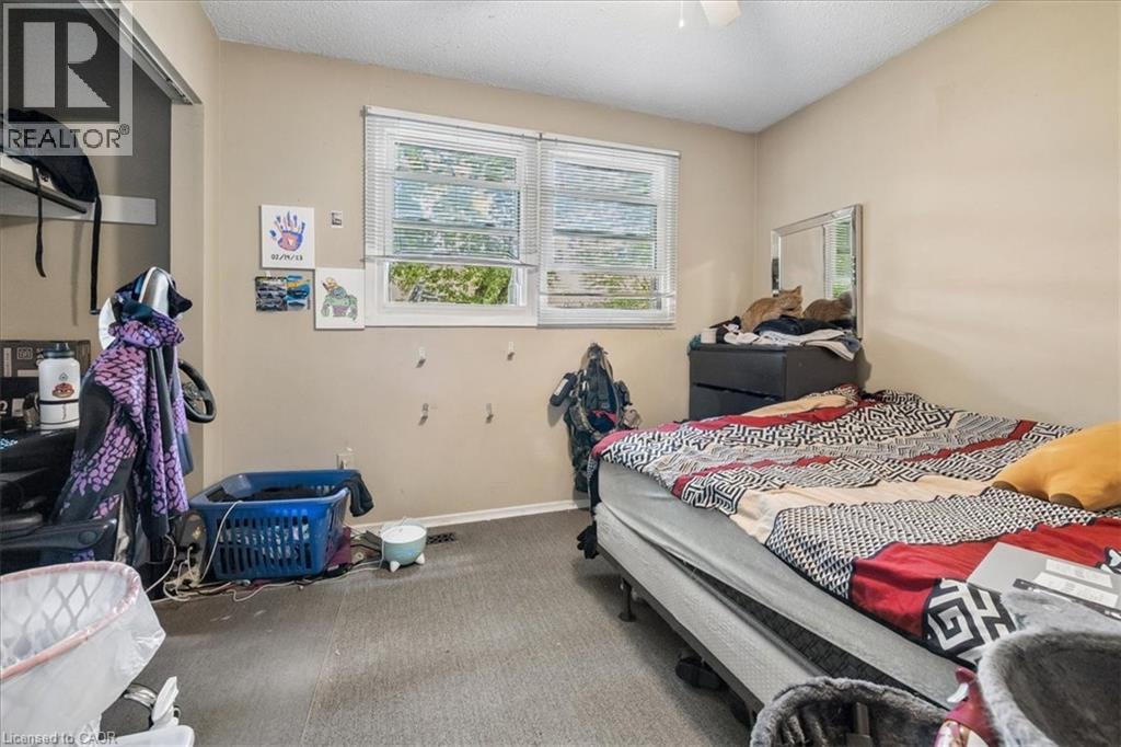 Bedroom featuring neutral wall paint, carpet flooring, a ceiling fan, and two windows with blinds - 80 Maclennan Avenue, Hamilton, ON
