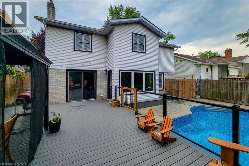 Multi-level composite deck with glass panel railing and an inground swimming pool - 29 Woodside Square, Fonthill, ON - Outdoor With In Ground Pool With Deck Patio Veranda With Exterior