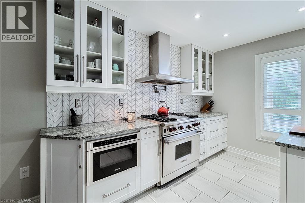 Gourmet kitchen with professional-grade stainless steel range, built-in microwave, and stainless steel hood vent - 29 Woodside Square, Fonthill, ON - Indoor Photo Showing Kitchen With Upgraded Kitchen