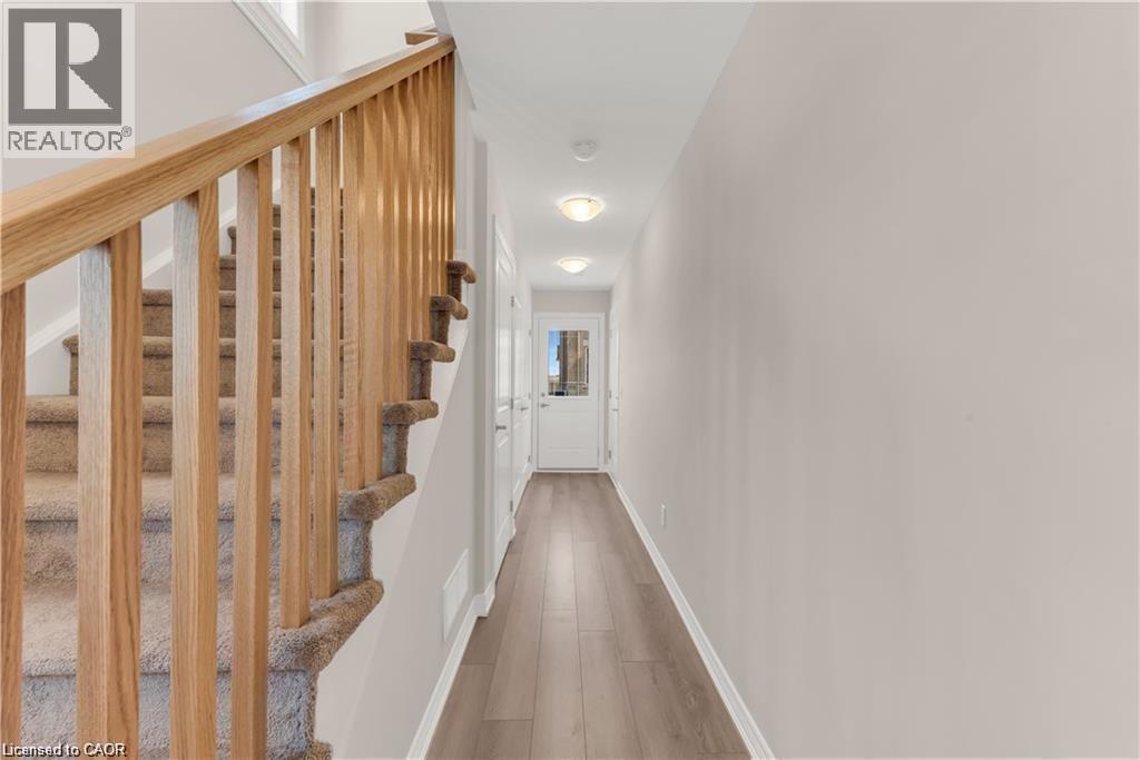 Entryway featuring wood-finish flooring and a carpeted staircase with wood banister - 19 Picardy Drive Unit# 9, Hamilton, ON