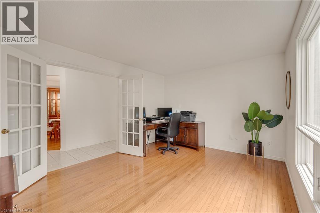 Hardwood-finish flooring throughout, featuring a bright window with vertical panes - 409 Jacqueline Boulevard, Hamilton, ON