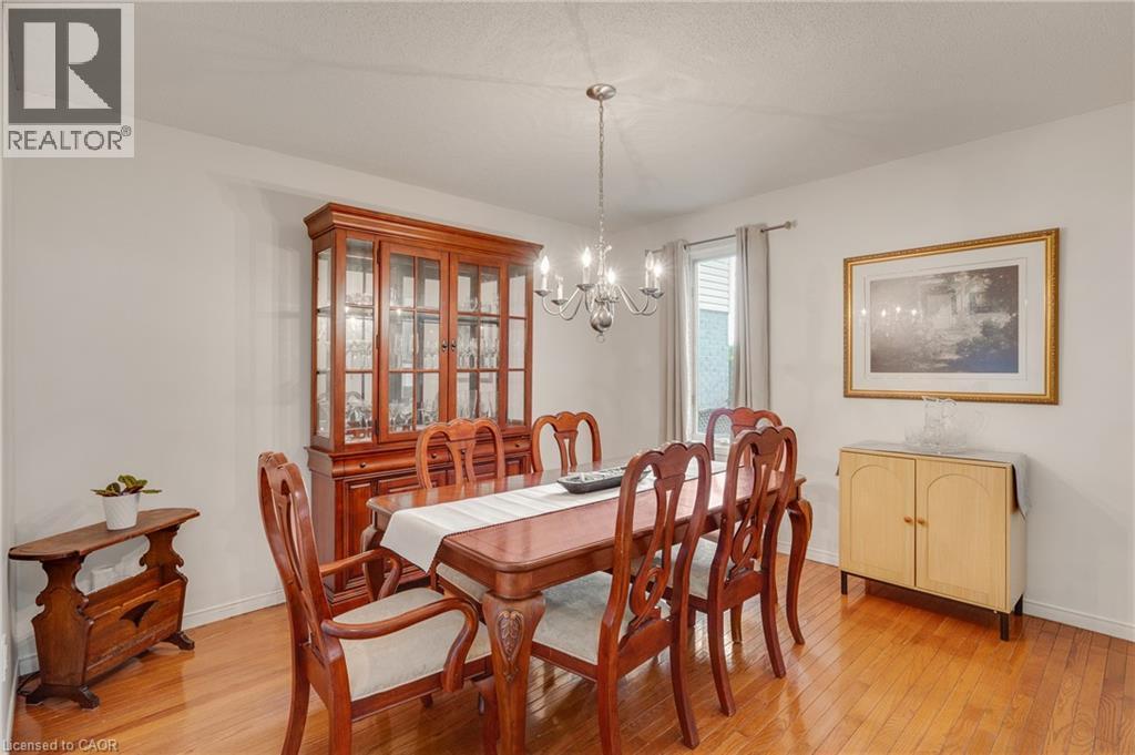 Dining area featuring wood-finish flooring and a central chandelier - 409 Jacqueline Boulevard, Hamilton, ON