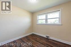 Light-filled interior space featuring wood-finish flooring, neutral wall tones, and white trim - 10 Collier Road, Thorold, ON