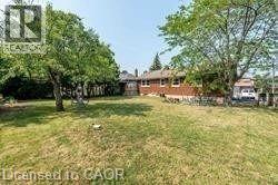 Expansive rear yard featuring mature trees and a detached structure - 10 Collier Road, Thorold, ON